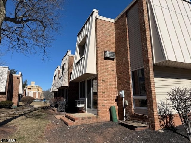 exterior space featuring brick siding and a balcony