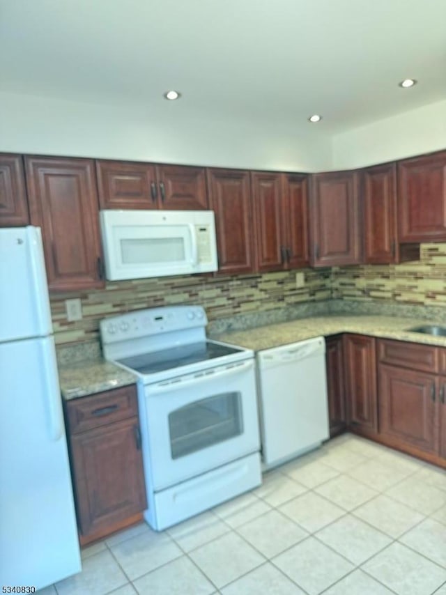 kitchen featuring decorative backsplash, white appliances, and light countertops