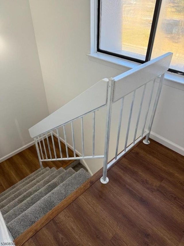 stairs featuring wood finished floors and baseboards