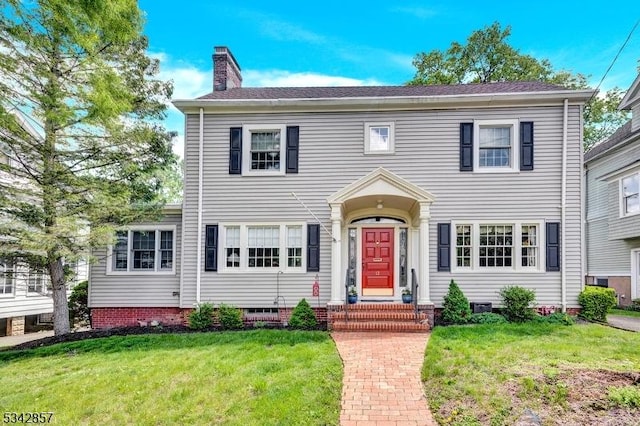 colonial-style house with a front lawn, a chimney, and crawl space