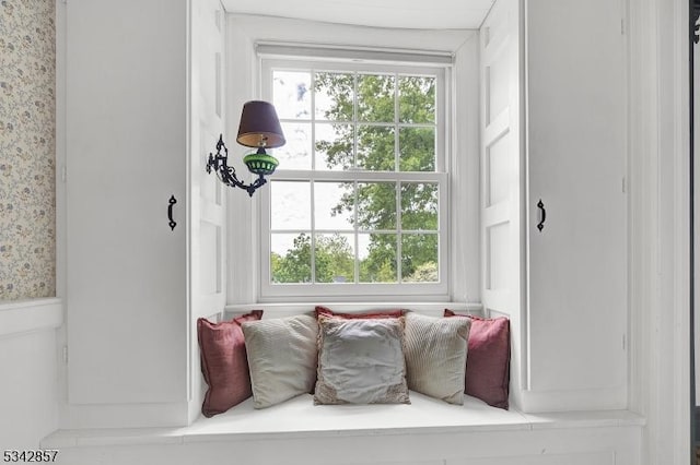 mudroom featuring healthy amount of natural light, wallpapered walls, and a wainscoted wall