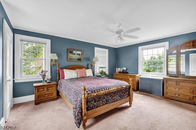 bedroom featuring light carpet, multiple windows, baseboards, ornamental molding, and radiator heating unit