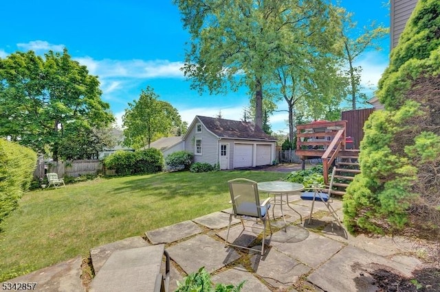 view of yard featuring an outdoor structure, a patio, and a garage