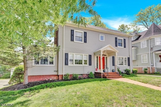 colonial inspired home featuring a front lawn