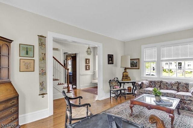 living room with stairway, wood finished floors, and baseboards
