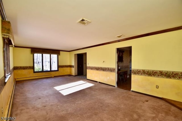 spare room with a baseboard heating unit, visible vents, a wainscoted wall, and carpet floors