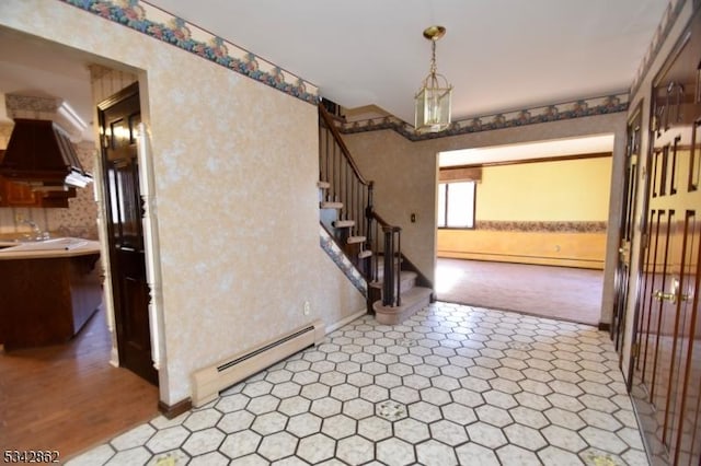 entrance foyer featuring wallpapered walls, stairs, baseboard heating, and a baseboard heating unit