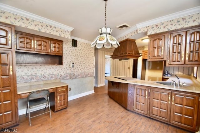 kitchen featuring visible vents, wallpapered walls, crown molding, light wood-style flooring, and a sink