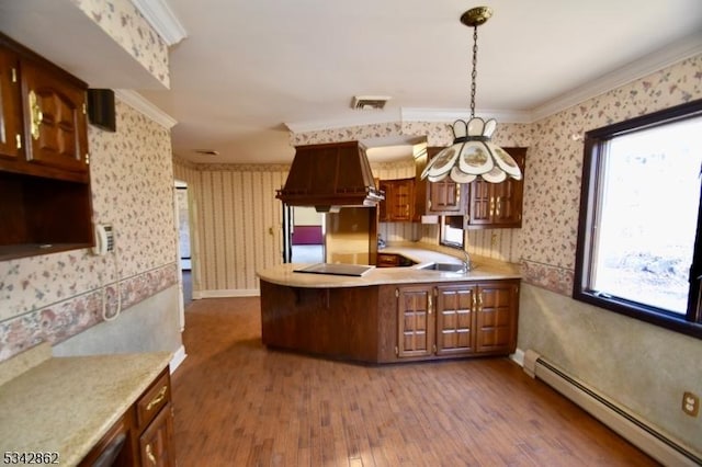 kitchen featuring wallpapered walls, light countertops, and a baseboard radiator