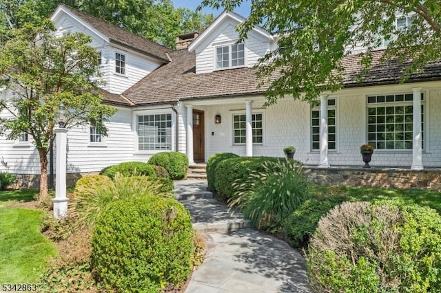 cape cod-style house featuring a chimney