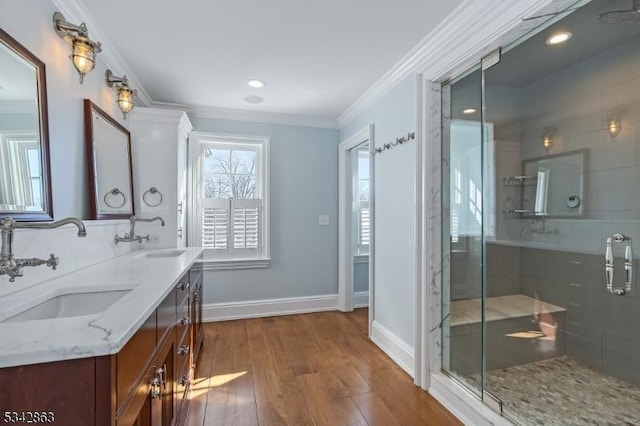 bathroom with ornamental molding, wood finished floors, and a sink