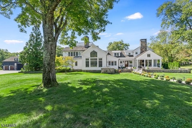 rear view of property with a lawn and a chimney