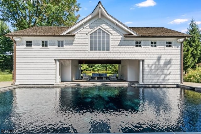 back of property with a carport, an outdoor hangout area, driveway, and a patio