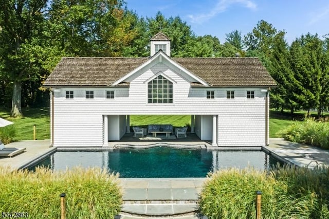 rear view of property with a patio area, an outdoor pool, outdoor lounge area, and a carport