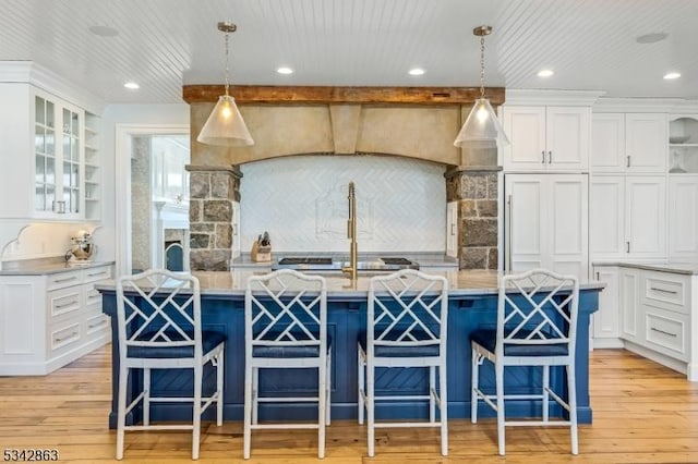 kitchen featuring glass insert cabinets, light wood-style floors, and white cabinets