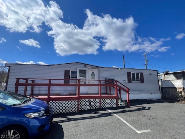 manufactured / mobile home with a wooden deck and uncovered parking