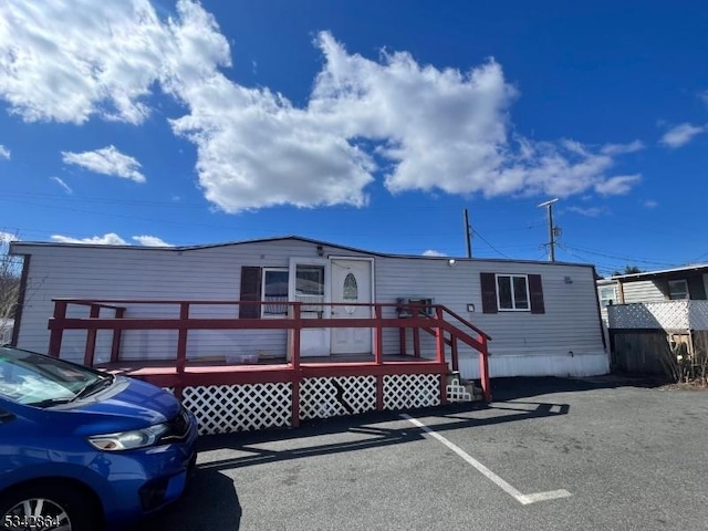 manufactured / mobile home featuring uncovered parking and a wooden deck