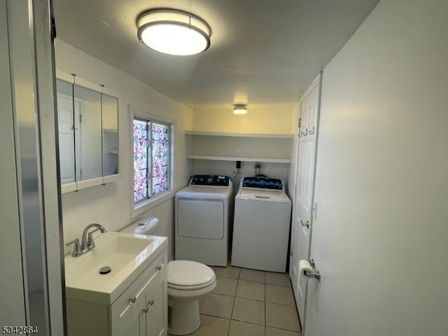 half bath with washer and dryer, toilet, vanity, and tile patterned flooring