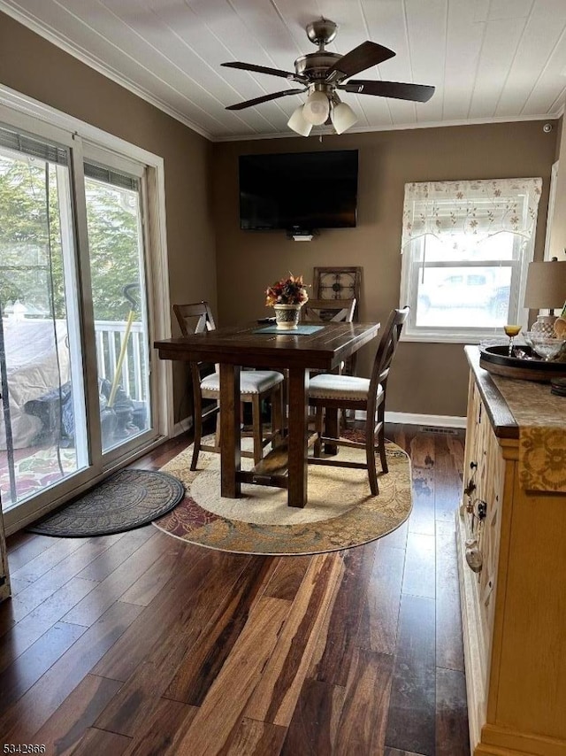 dining room with ceiling fan, dark wood-type flooring, baseboards, and ornamental molding