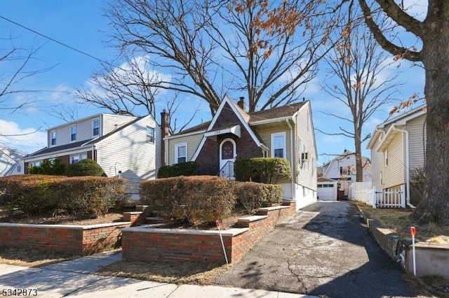 view of front of property featuring aphalt driveway and an outbuilding