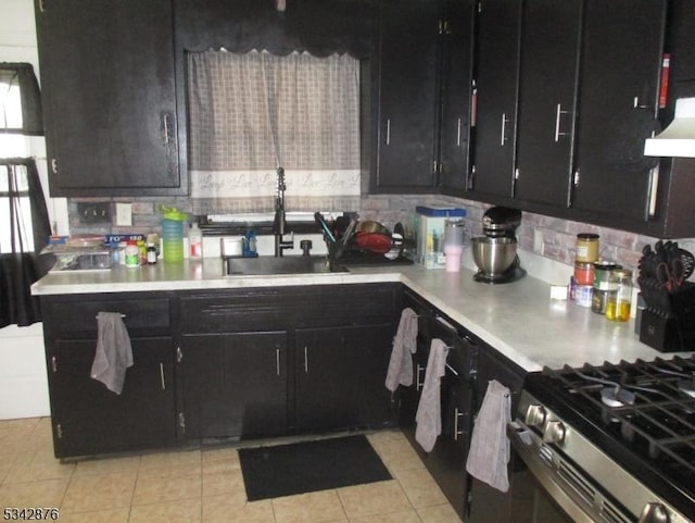 kitchen with a sink, dark cabinets, and light countertops