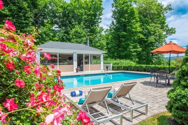 view of swimming pool with an outbuilding, a fenced in pool, a patio, and fence