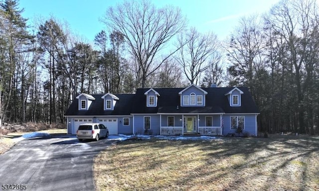 cape cod home with a porch, an attached garage, a front lawn, and driveway