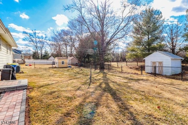 view of yard with a storage unit, an outbuilding, and a fenced backyard