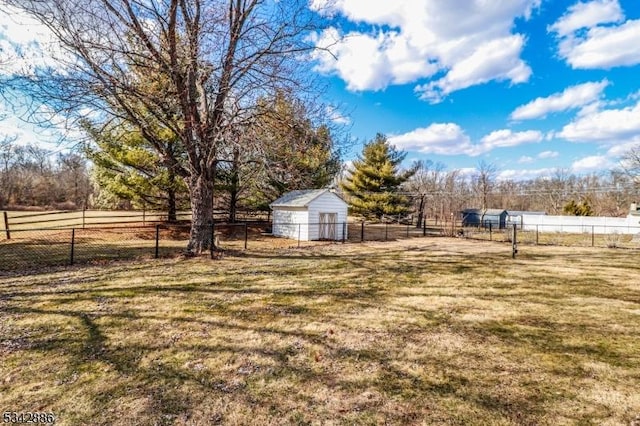 view of yard with an outbuilding, a rural view, and fence