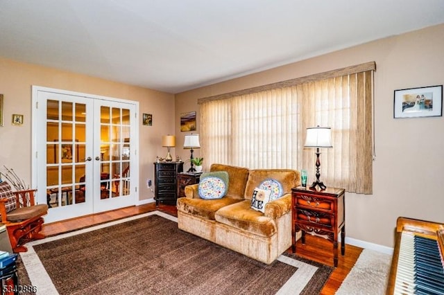 living room featuring wood finished floors, french doors, and baseboards