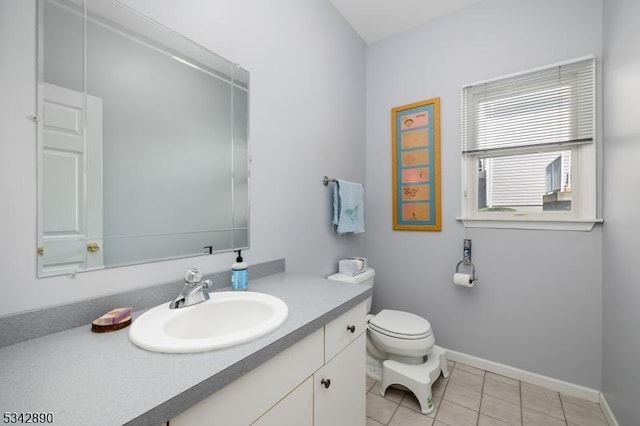 bathroom with baseboards, toilet, vanity, and tile patterned flooring