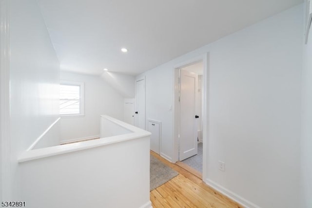 hallway featuring an upstairs landing, recessed lighting, light wood-type flooring, and baseboards