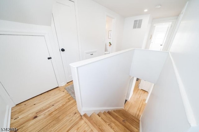 hall featuring an upstairs landing, visible vents, recessed lighting, and light wood-style floors