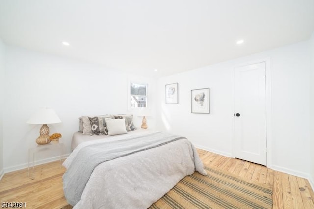 bedroom with light wood finished floors, recessed lighting, and baseboards