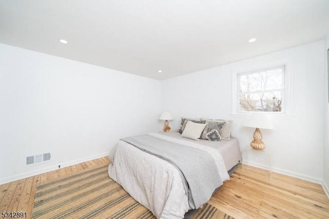 bedroom with light wood finished floors, visible vents, recessed lighting, and baseboards