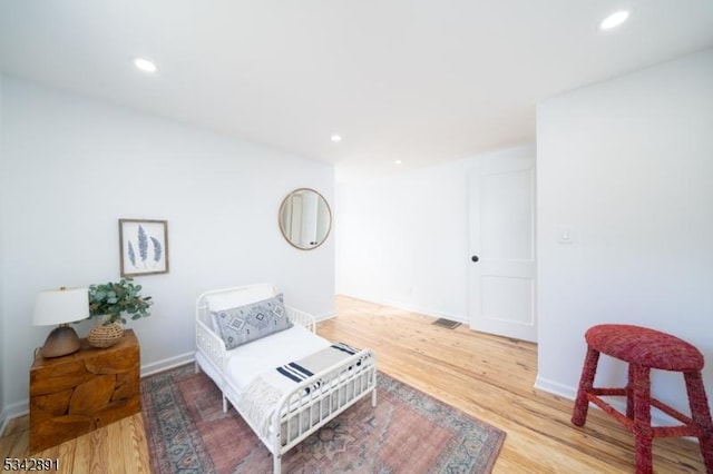 bedroom with recessed lighting, light wood-type flooring, and baseboards