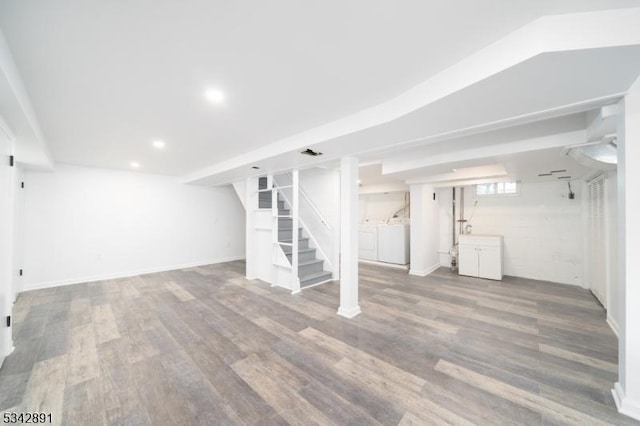 below grade area with wood finished floors, stairway, recessed lighting, and washing machine and dryer