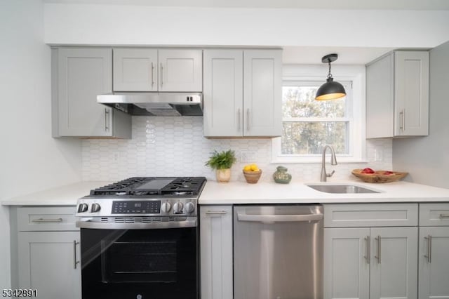 kitchen featuring under cabinet range hood, appliances with stainless steel finishes, and gray cabinets