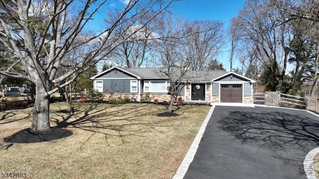 ranch-style house featuring aphalt driveway, a garage, fence, and stone siding