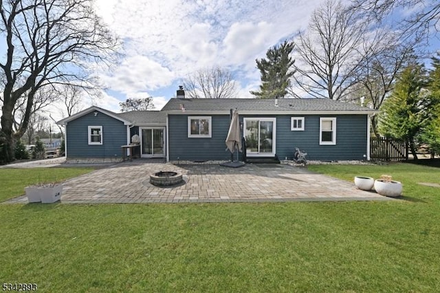 rear view of property with a yard, a patio area, and an outdoor fire pit