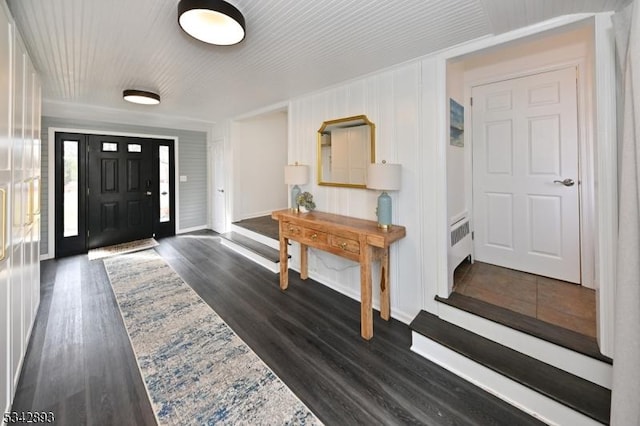 entryway featuring dark wood-style floors, radiator heating unit, and baseboards