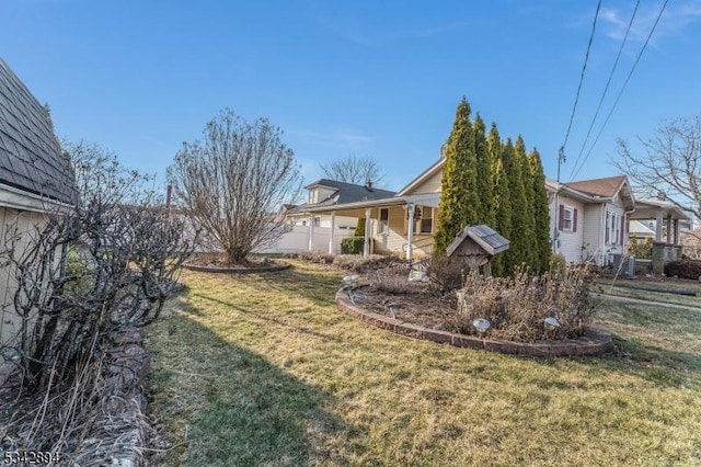 view of side of property with a yard and an attached garage