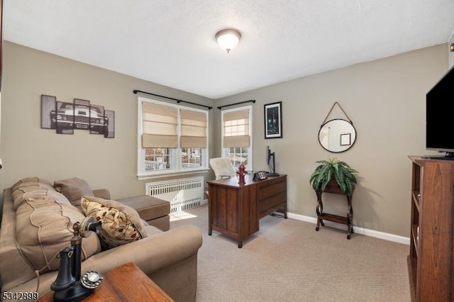 office area with baseboards, light carpet, and radiator