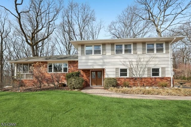 tri-level home featuring brick siding and a front lawn