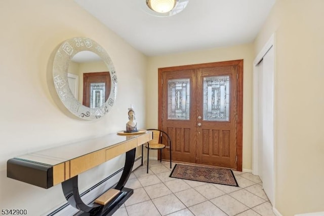 foyer featuring light tile patterned floors and baseboards