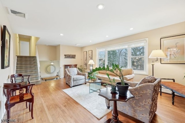 living room featuring visible vents, recessed lighting, stairway, and wood finished floors