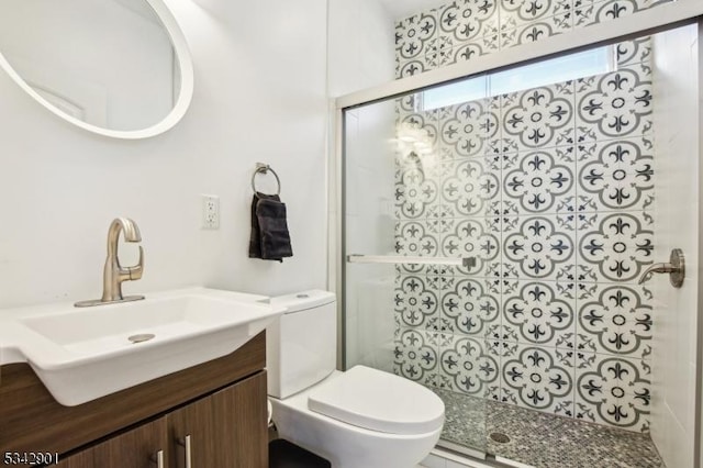 bathroom featuring toilet, tiled shower, and vanity