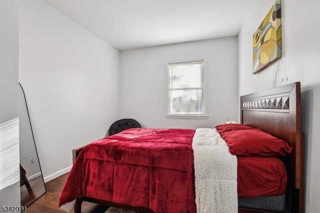 bedroom with wood finished floors and baseboards