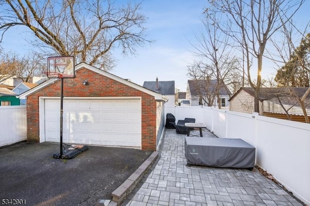 view of patio / terrace with an outbuilding, fence, and a detached garage