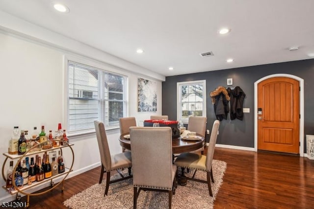 dining room featuring arched walkways, recessed lighting, baseboards, and wood finished floors